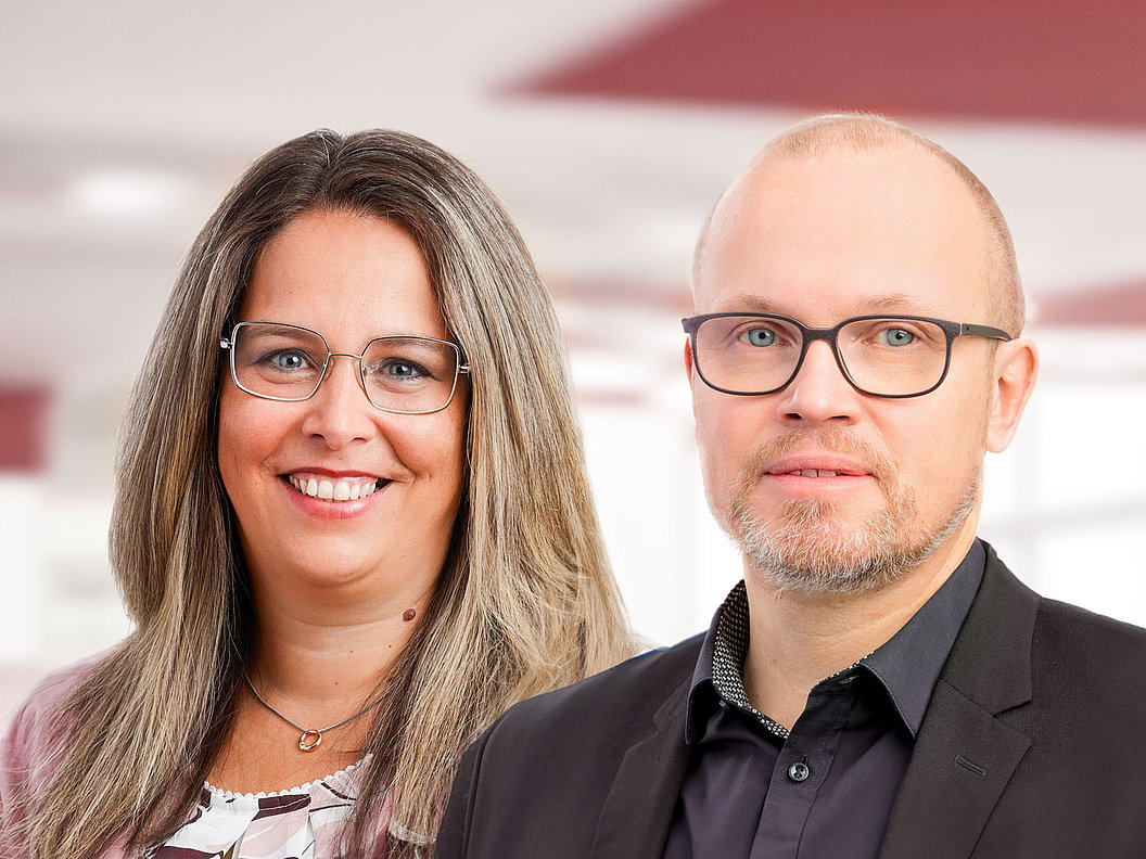 Anke Klauck mit langen braunblonden Haaren und Christian Link mit Brille und kurzem Haar, beide in Businesskleidung vor hellem Hintergrund